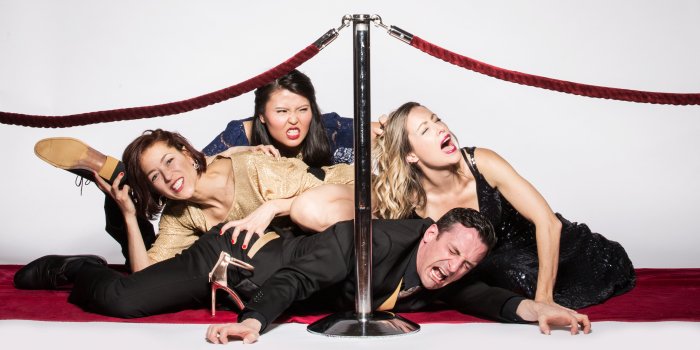 Four actors pretend to fight behind a velvet rope. Publicity still for The Money Shot. 