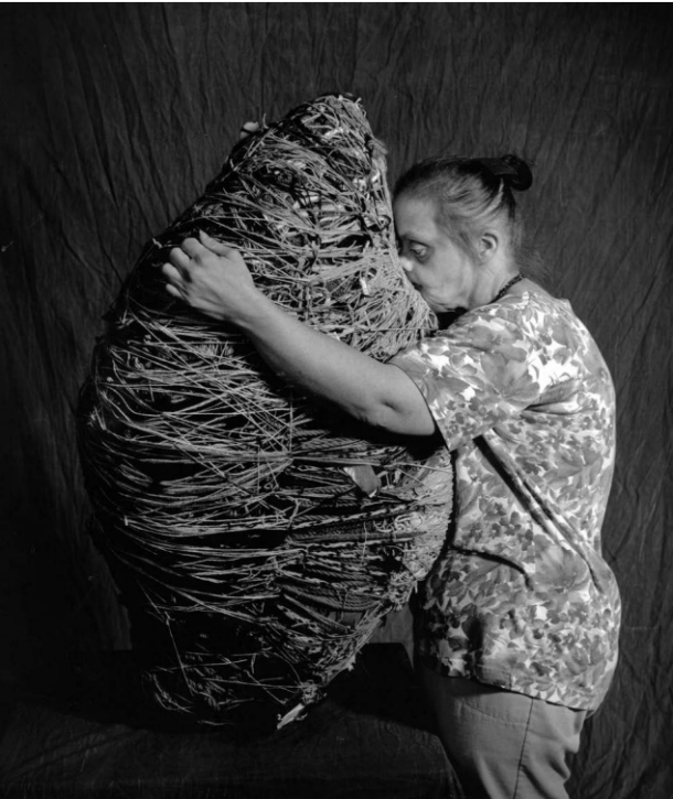 Sculptor Judith Scott hugging one of her pieces